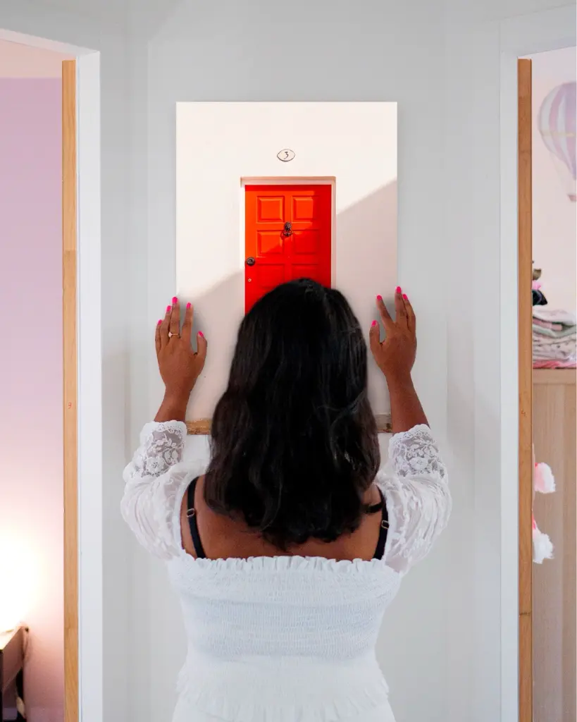 Porte_Rouge_aluminium_femme_mur.webp